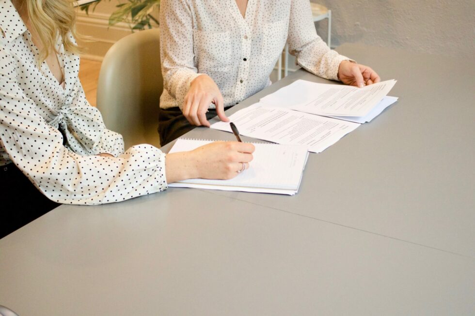 Two people signing a contract